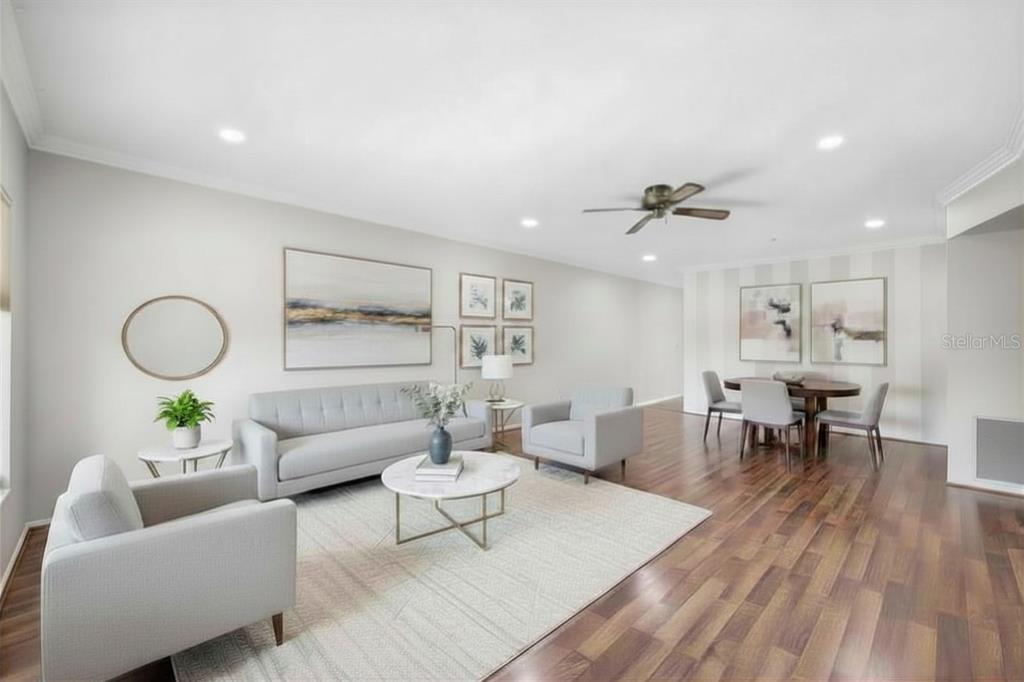 A bright living and dining area features light gray furniture, a round coffee table, and wood-look flooring — 2381 ECUADORIAN WAY UNIT 45, CLEARWATER, FL