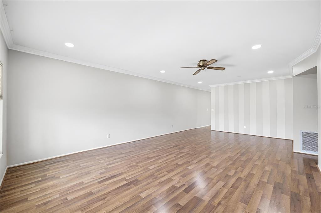 An empty room with wood-look flooring, recessed lighting, a ceiling fan, and striped wallpaper — 2381 ECUADORIAN WAY UNIT 45, CLEARWATER, FL