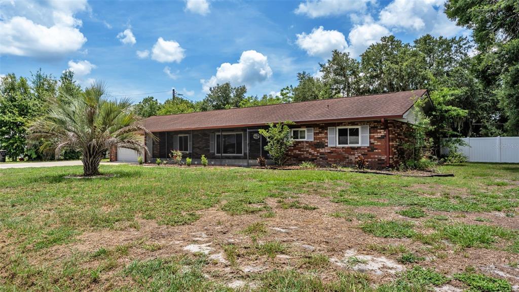 A single-story brick house with a brown roof sits on a grassy lot — 3180 FLAMINGO LANE, MULBERRY, FL