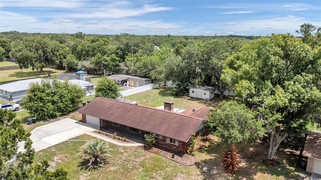 An aerial view shows a single-story brick house with a brown roof and backyard — 3180 FLAMINGO LANE, MULBERRY, FL