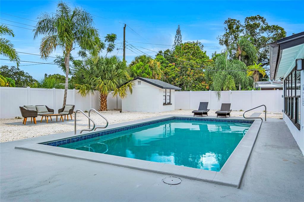A backyard features a rectangular swimming pool, a small white shed, and patio furniture — 1921 FERN AVENUE, SARASOTA, FL