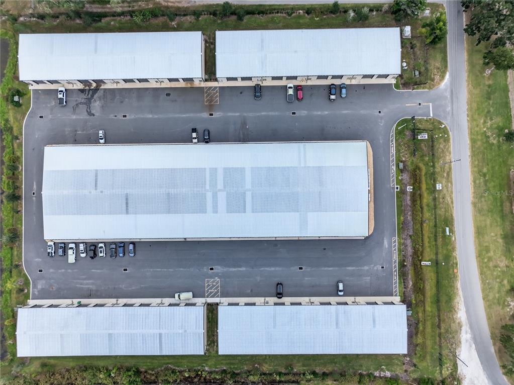 An aerial view shows three commercial storage buildings with parking lots and surrounding green space — 4707 COUNTY ROAD 156, WILDWOOD, FL