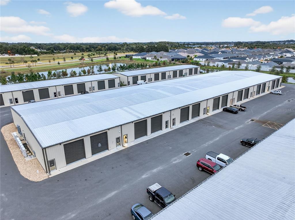 An aerial view shows two long, single-story commercial storage buildings with metal roofs and parking lots — 4707 COUNTY ROAD 156, WILDWOOD, FL