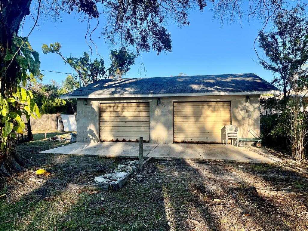 A detached concrete block garage with two roll-up doors sits on a concrete slab — W SPRUCE STREET, TARPON SPRINGS, FL