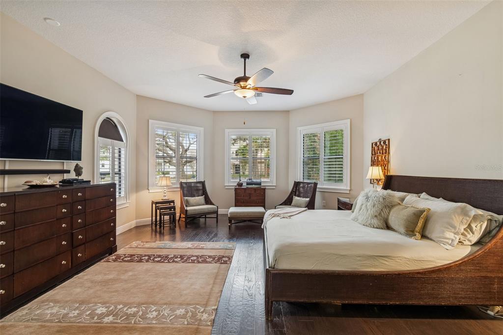 A bedroom features dark wood floors, a sleigh bed, a dresser, and three bay windows — 2906 W HAWTHORNE ROAD, TAMPA, FL