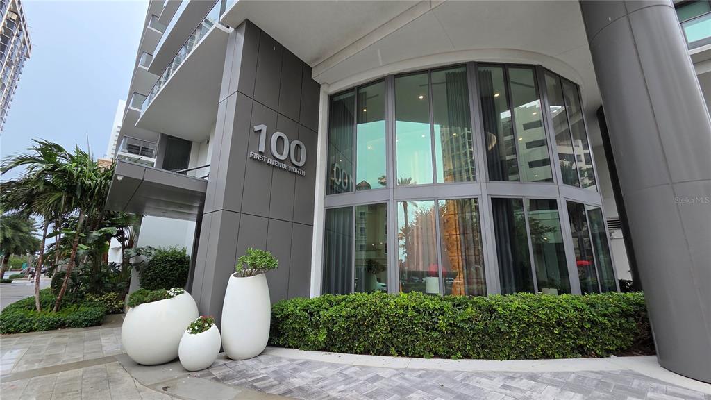 The exterior of a modern building features large glass windows, gray panels, and decorative planters — 100 1ST AVENUE N UNIT 2406, ST PETERSBURG, FL