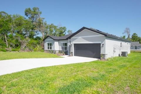 A single-story house with a gray exterior, a two-car garage, and a concrete driveway — 604 MARION OAKS LANE, OCALA, FL