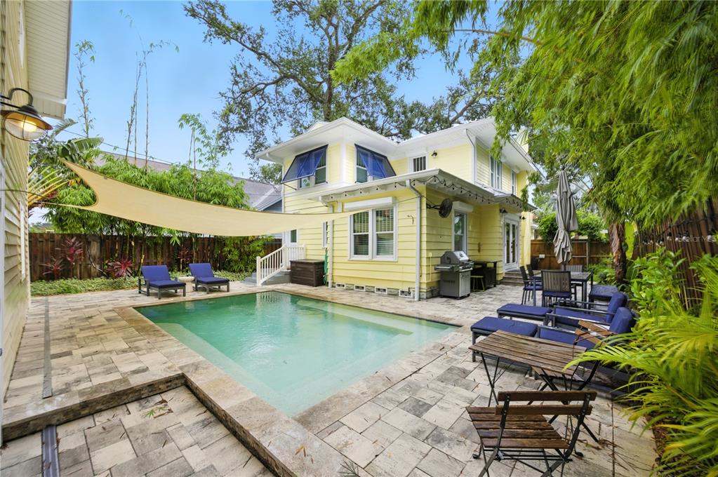A yellow two-story house with a swimming pool and patio in a fenced backyard — 221 13TH AVENUE NE, ST PETERSBURG, FL