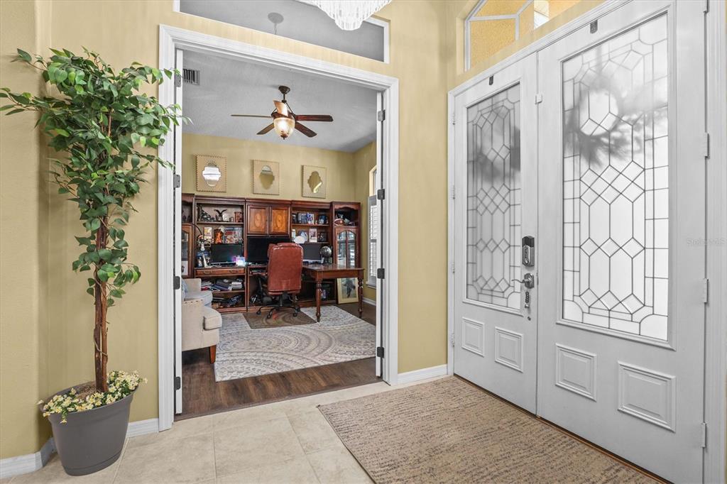 A foyer with tile flooring leads into a home office through double doors — 8331 GOLDEN PRAIRIE DRIVE, TAMPA, FL