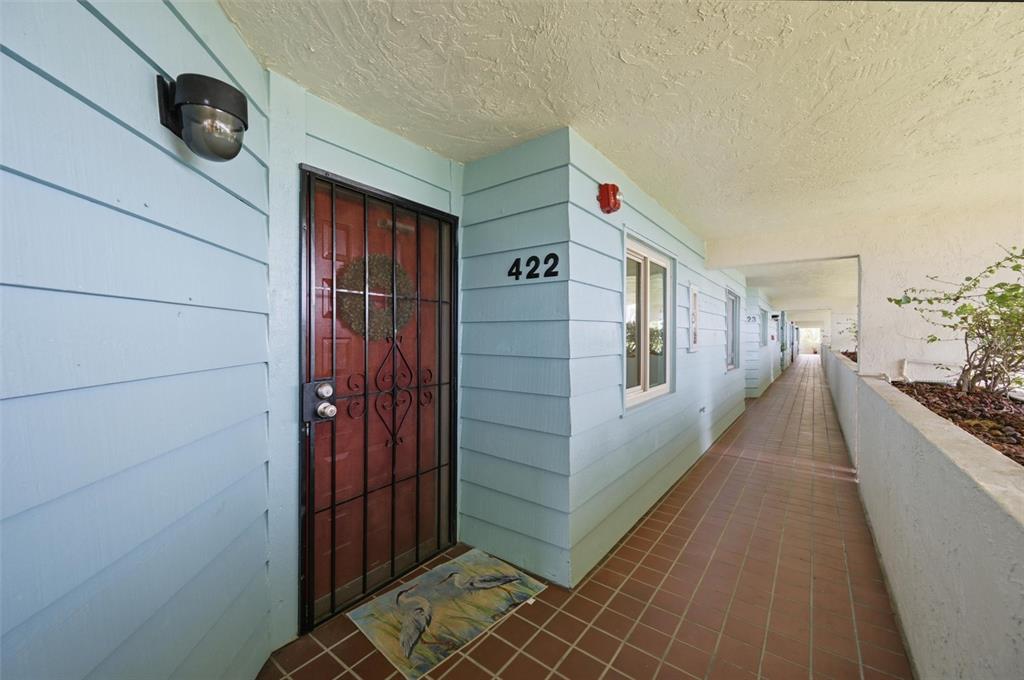 An exterior view of a light blue apartment unit with a metal security door — 9604 CORTEZ ROAD W UNIT 422, BRADENTON, FL