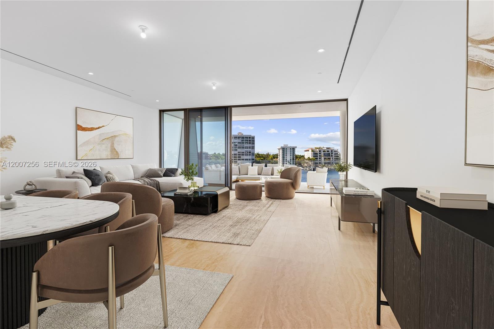 A modern living and dining area features neutral furniture, marble tables, and a balcony view — 5 Grove Isle Dr # S401, Miami FL 33133, MIAMI, FL