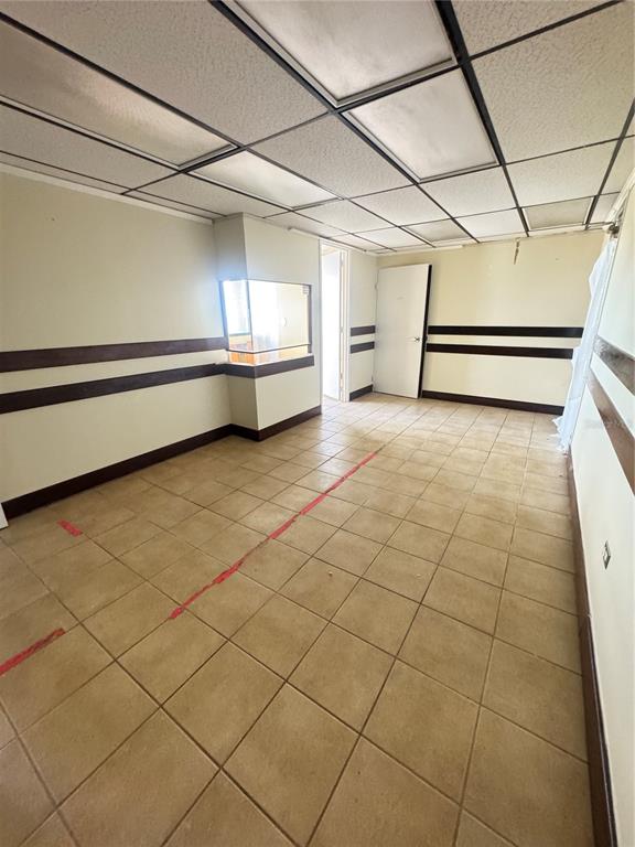 An empty room features beige tile flooring, a drop ceiling, and dark horizontal wall trim — Cond Torre San Pablo SANTA CRUZ UNIT 805, BAYAMON, PR
