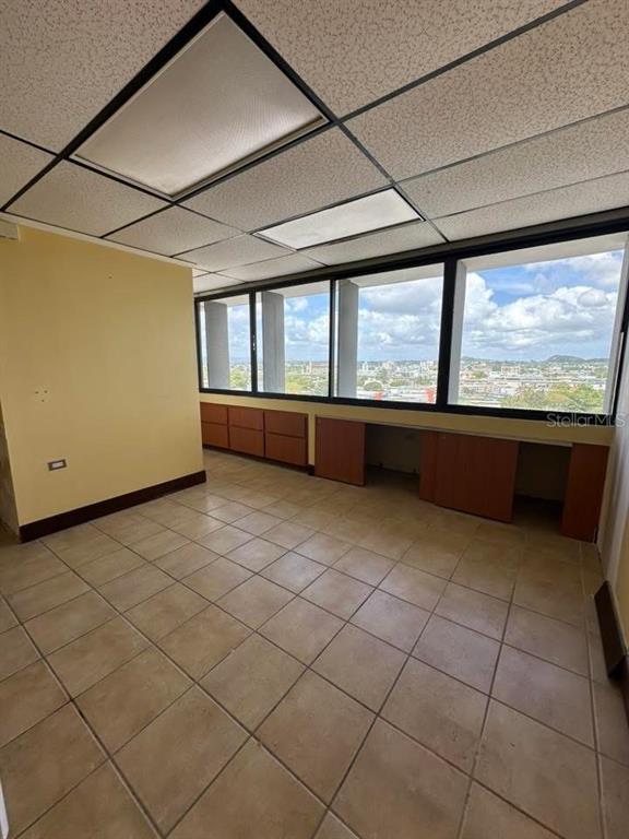 An office room features beige tile floors, a drop ceiling, and built-in wooden cabinets — Cond Torre San Pablo SANTA CRUZ UNIT 805, BAYAMON, PR