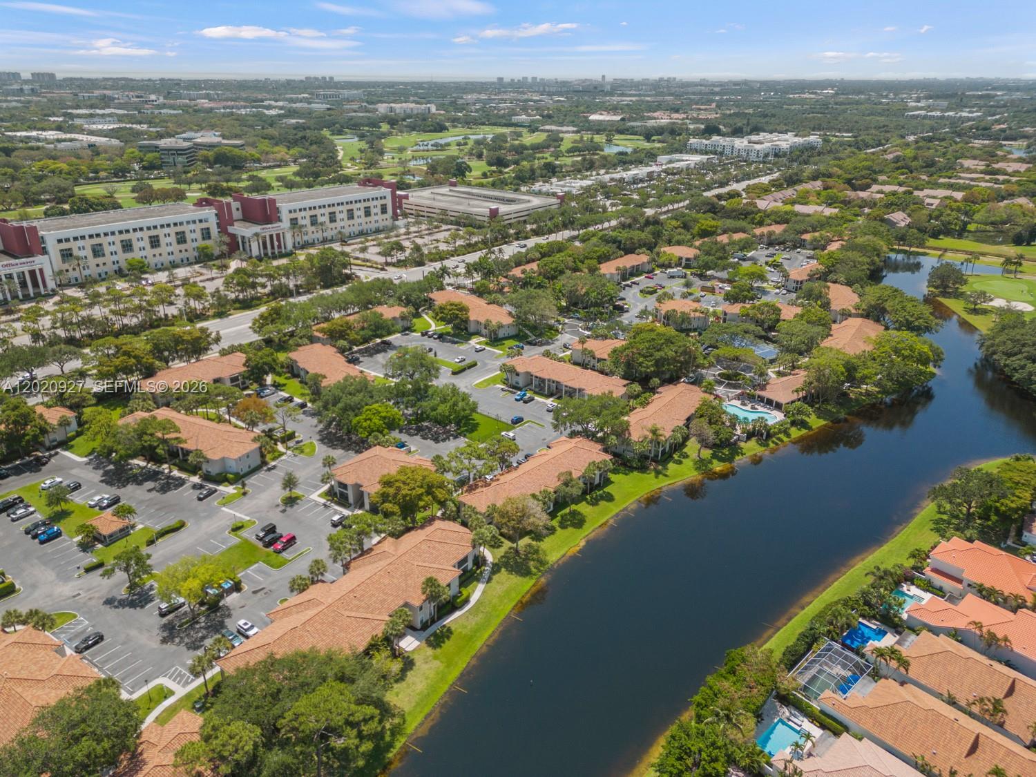 An aerial view shows a residential complex with tiled roofs, parking lots, and a lake — 6503 N Military Trl, Boca Raton FL 33496, BOCA RATON, FL