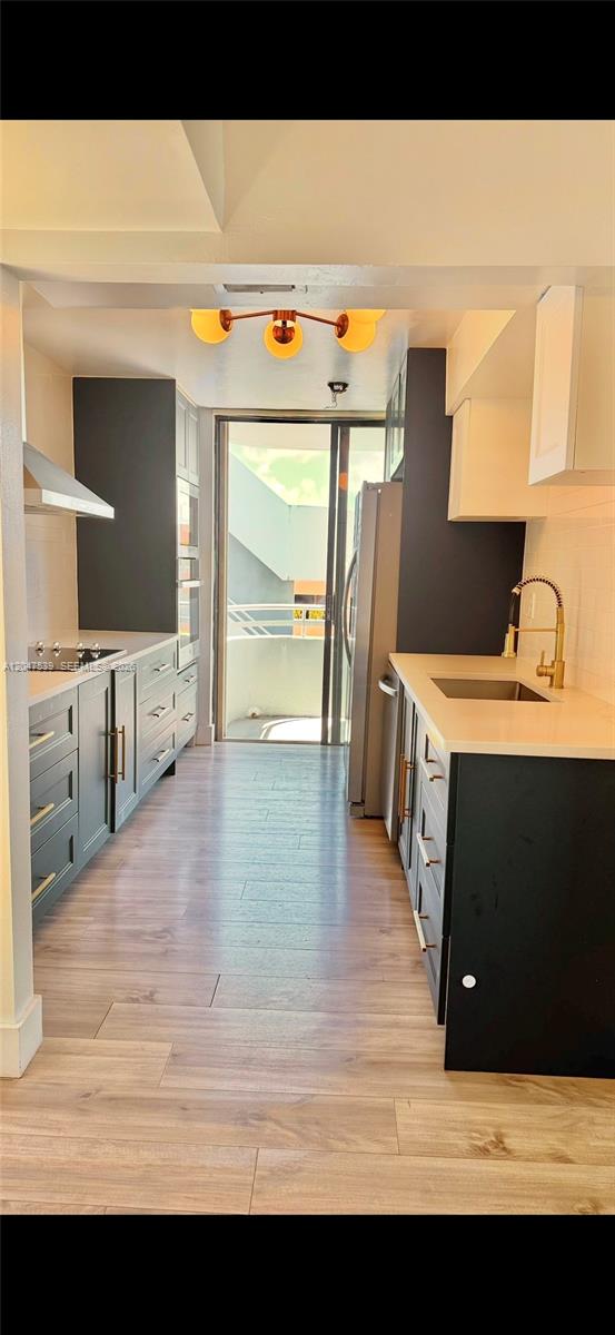 A galley kitchen features dark cabinets, light countertops, gold hardware, and a sliding glass door — 8201 Byron Ave # 501, Miami Beach FL 33141, MIAMI BEACH, FL
