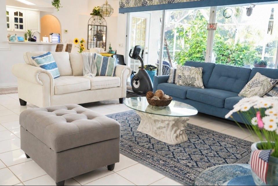 A living room features a white sofa, a blue sofa, and a glass-topped coffee table — 10535 AZTEC ROAD, PORT CHARLOTTE, FL