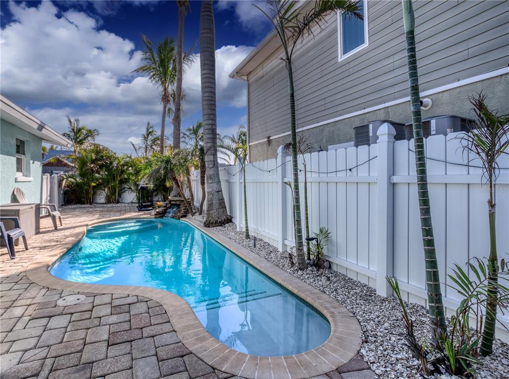 A backyard swimming pool with a stone paver deck and a white vinyl privacy fence — 3604 GULF DRIVE UNIT A and B, HOLMES BEACH, FL