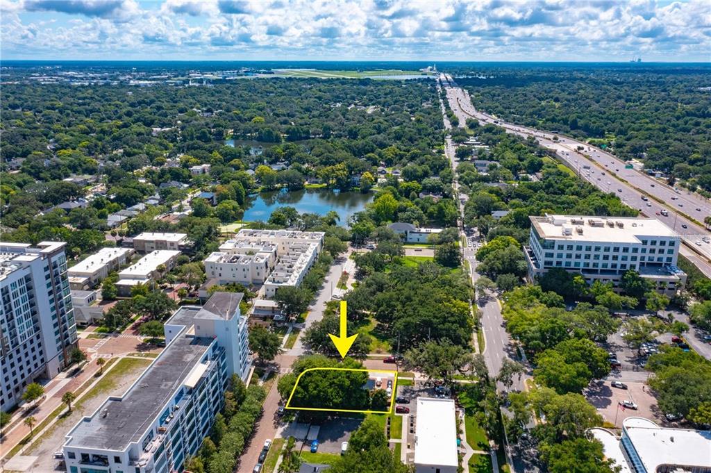 An aerial view shows a rectangular, tree-covered lot outlined in yellow near a city street — 300 S EOLA DRIVE, ORLANDO, FL