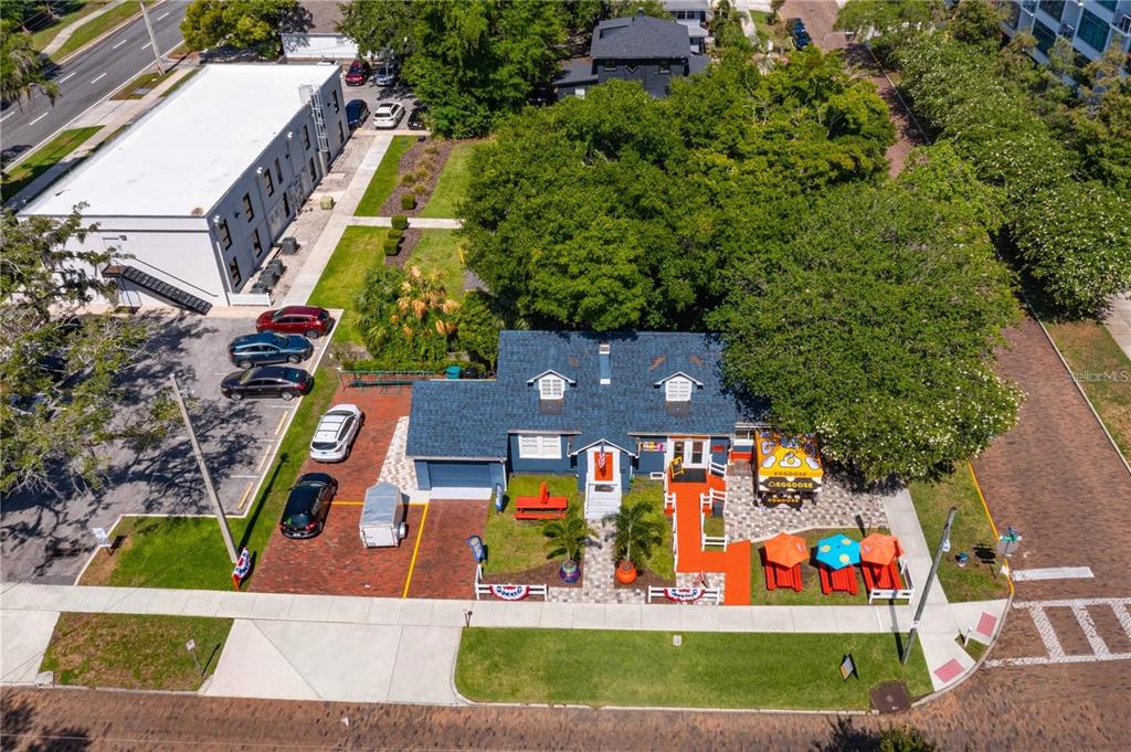An aerial view shows a blue house with a brick patio, outdoor seating, and parking — 300 S EOLA DRIVE, ORLANDO, FL