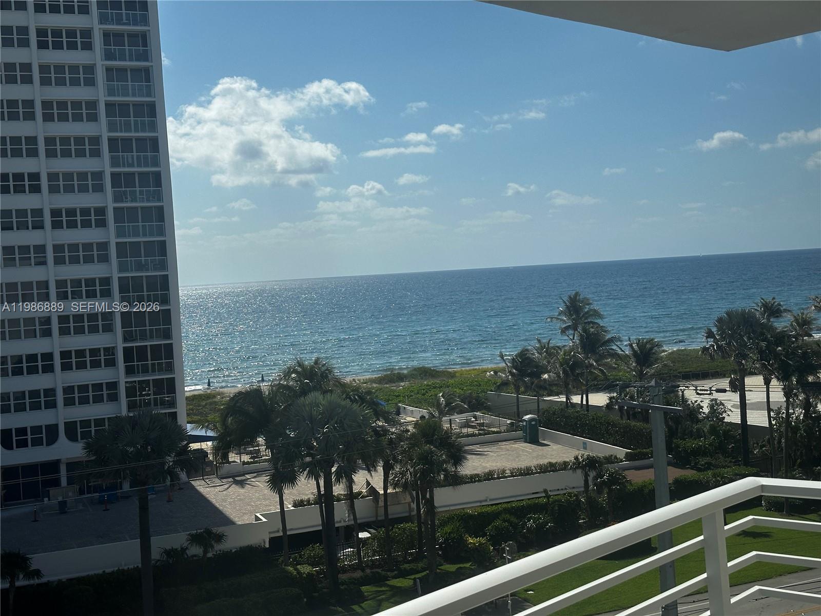 A view from a balcony overlooking palm trees, a parking area, and the ocean — 2851 S Ocean Boulevard # V, Boca Raton FL 33432, BOCA RATON, FL