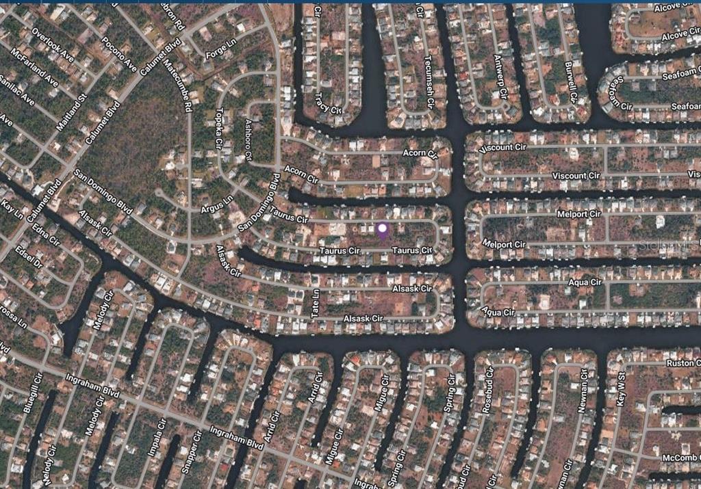 This is an aerial map view of a residential neighborhood with canal-front homes — 15277 TAURUS CIRCLE, PORT CHARLOTTE, FL