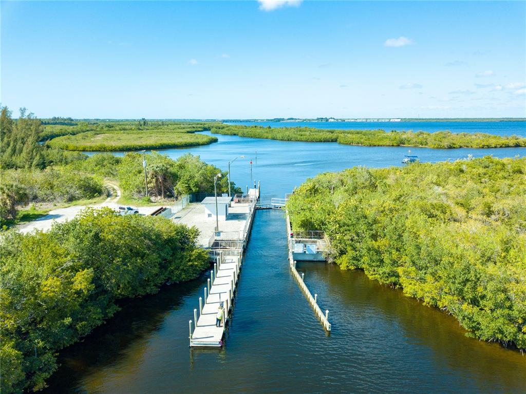 An aerial view shows a boat dock and a small structure surrounded by dense vegetation — 15277 TAURUS CIRCLE, PORT CHARLOTTE, FL
