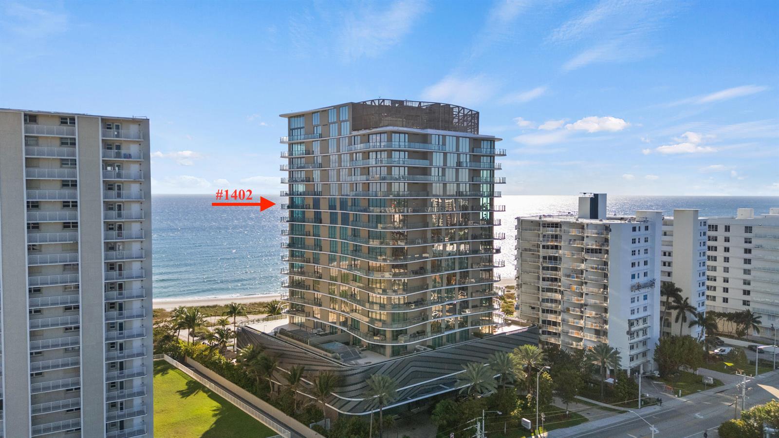 An exterior view of a modern high-rise beachfront condominium building with a red arrow — 730 N Ocean Boulevard # 1402, Pompano Beach FL 33062, POMPANO BEACH, FL