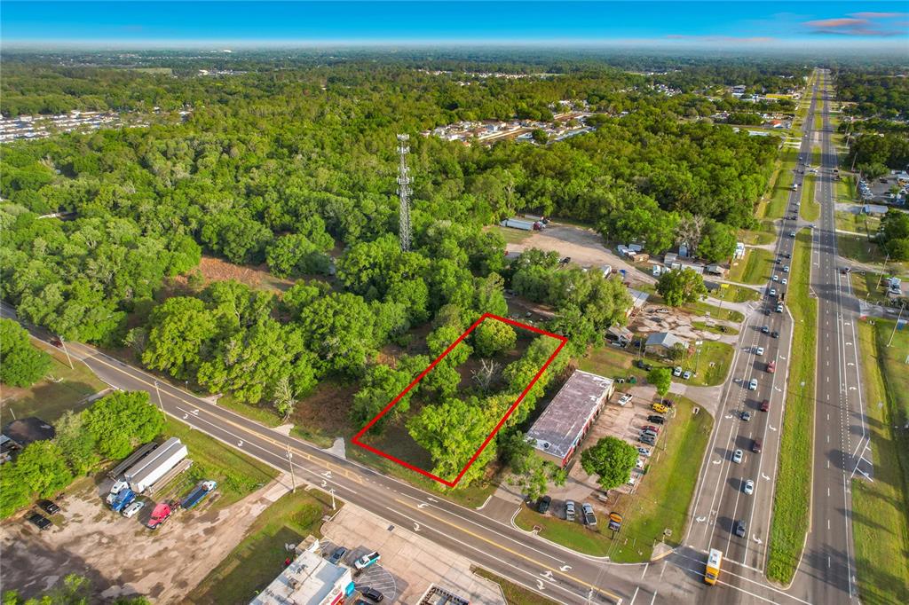 An aerial view shows a rectangular plot of land outlined in red near a highway — 1225 DUFF ROAD, LAKELAND, FL