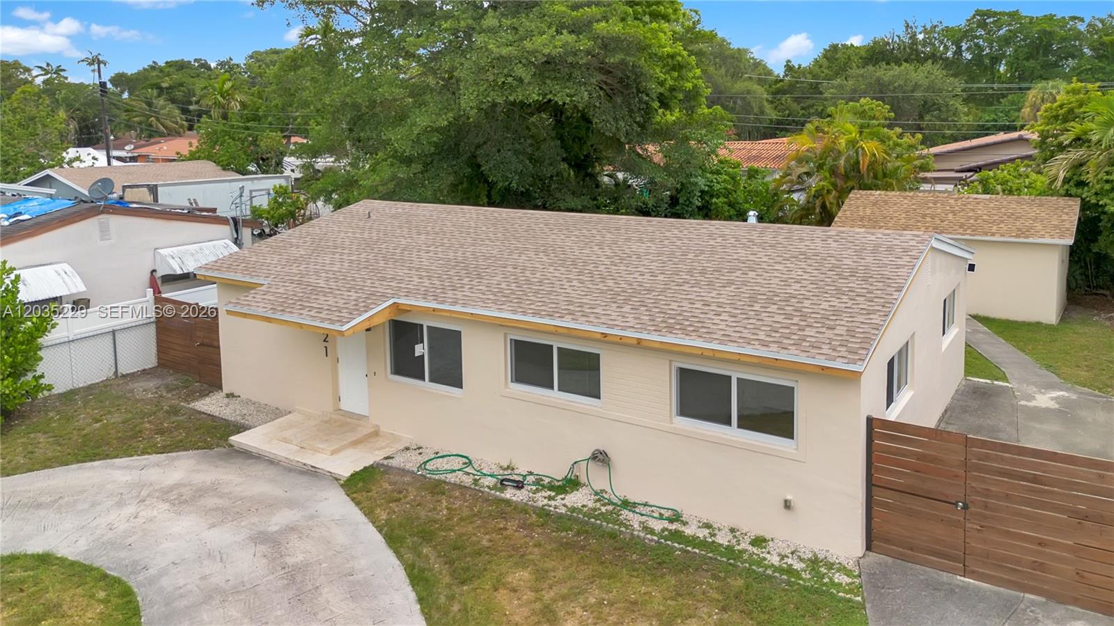 A single-story house with a tan exterior, a brown shingled roof, and a wooden fence — 321 NW 56th Av, Miami FL 33126, MIAMI, FL