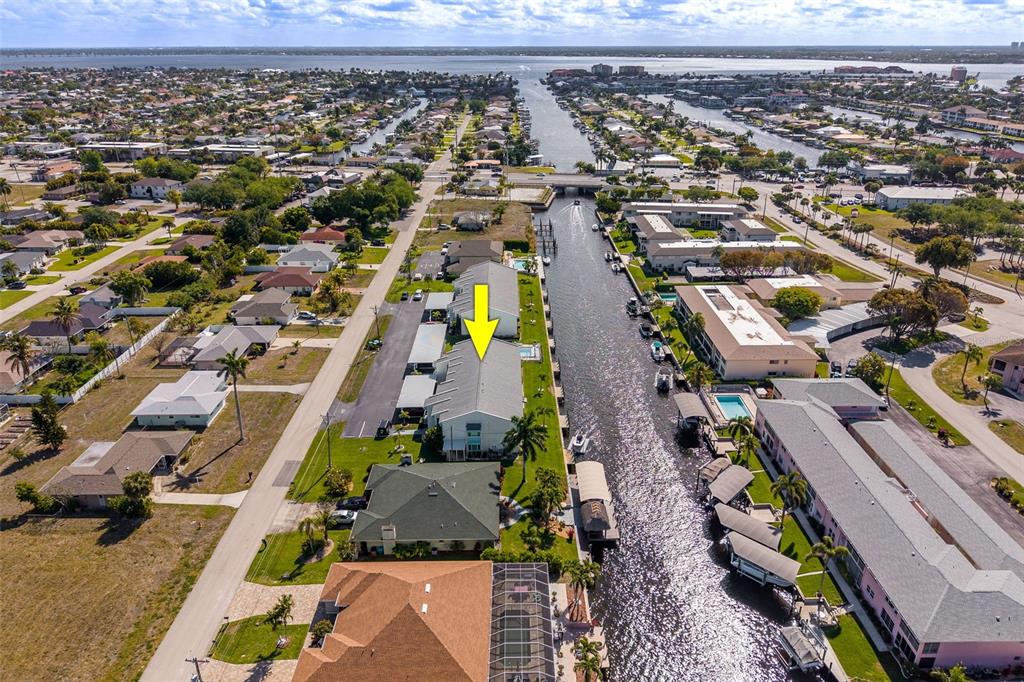An aerial view shows a multi-unit residential building with a yellow arrow pointing downward — 1322 SE 40TH STREET UNIT 2, CAPE CORAL, FL