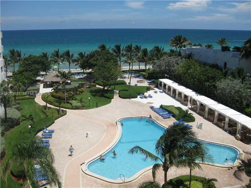 An aerial view of a swimming pool, lounge area, and beach at a coastal resort — 3001 S Ocean Dr # 1449, Hollywood FL 33019, HOLLYWOOD, FL