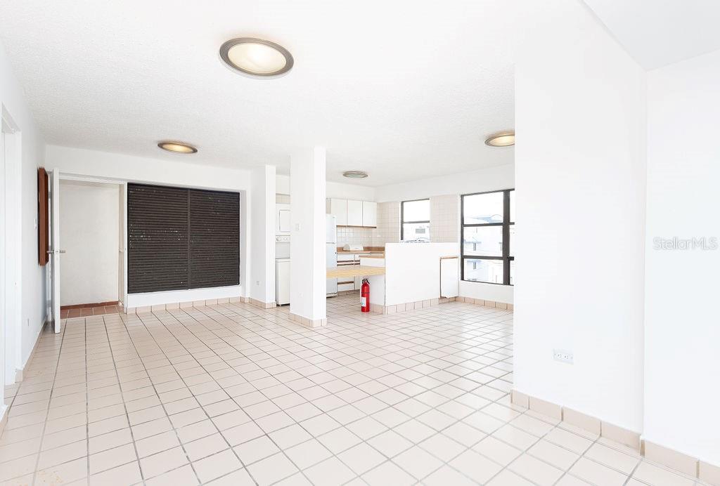 An open-concept living and kitchen area features white walls and light-colored tiled flooring — 277 SAN JORGE UNIT 202, SAN JUAN, PR