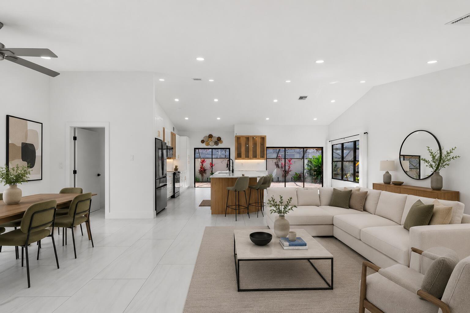 An open-concept living and dining area features white tile floors, a kitchen island, and furniture — 21326 Campo Allegro Drive, Boca Raton FL 33433, BOCA RATON, FL