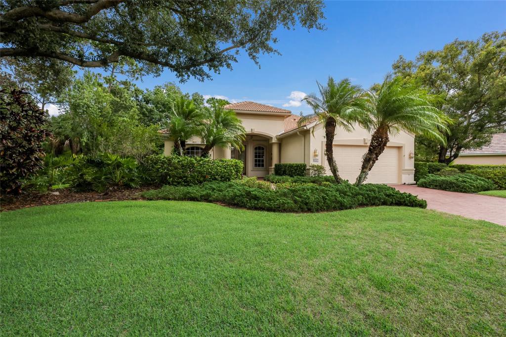 A single-story house with a tiled roof, two-car garage, and palm trees in the front yard — 8005 WATERVIEW BOULEVARD, LAKEWOOD RANCH, FL