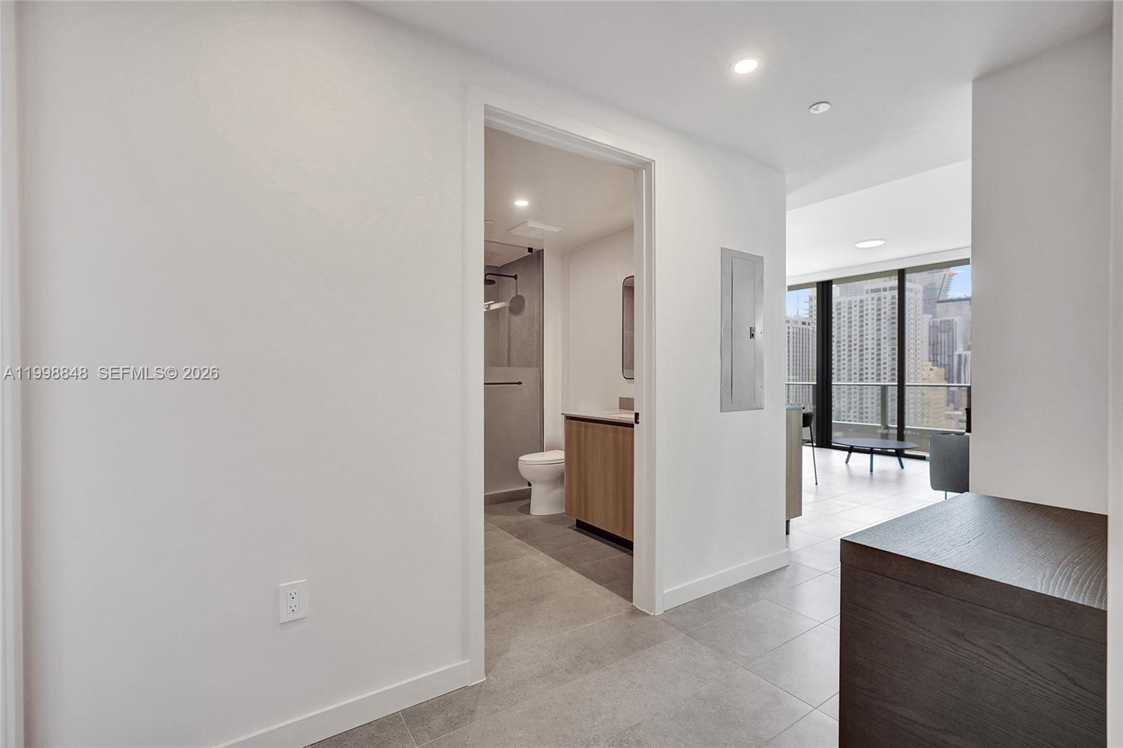 A hallway leads to a bathroom with a vanity and shower, adjacent to a living area — 121 NE 5th ST # 2101, Miami FL 33132, MIAMI, FL