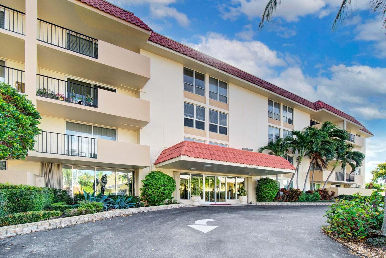 The exterior of a multi-story apartment building features a red tile roof and entrance canopy — 1000 Spanish River Road # 3k, Boca Raton FL 33432, BOCA RATON, FL