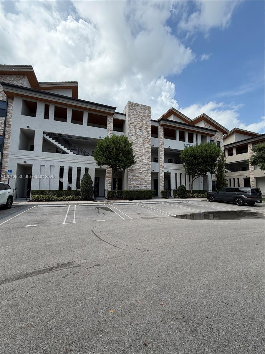 A multi-story apartment building features a stone facade, stucco walls, and an open parking lot — 8195 NW 104th Ave # 22, Doral FL 33178, DORAL, FL