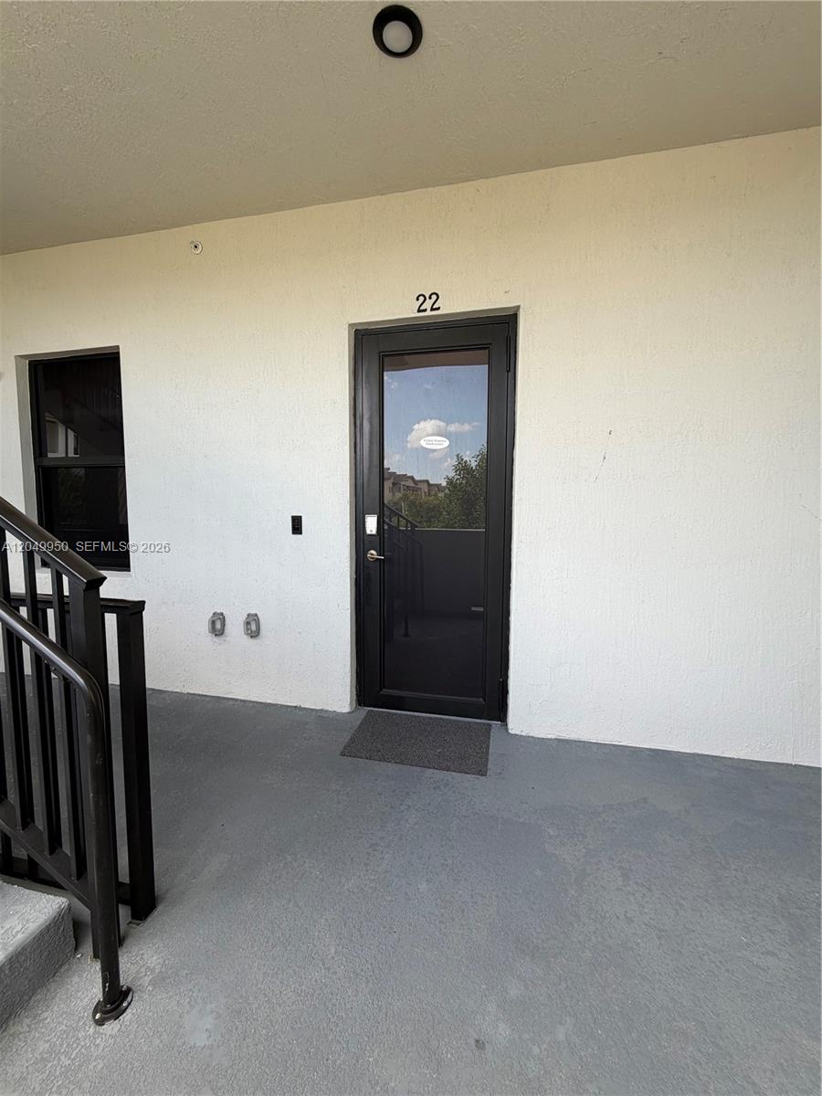 This exterior view shows a building entrance with a black door labeled number 22 — 8195 NW 104th Ave # 22, Doral FL 33178, DORAL, FL