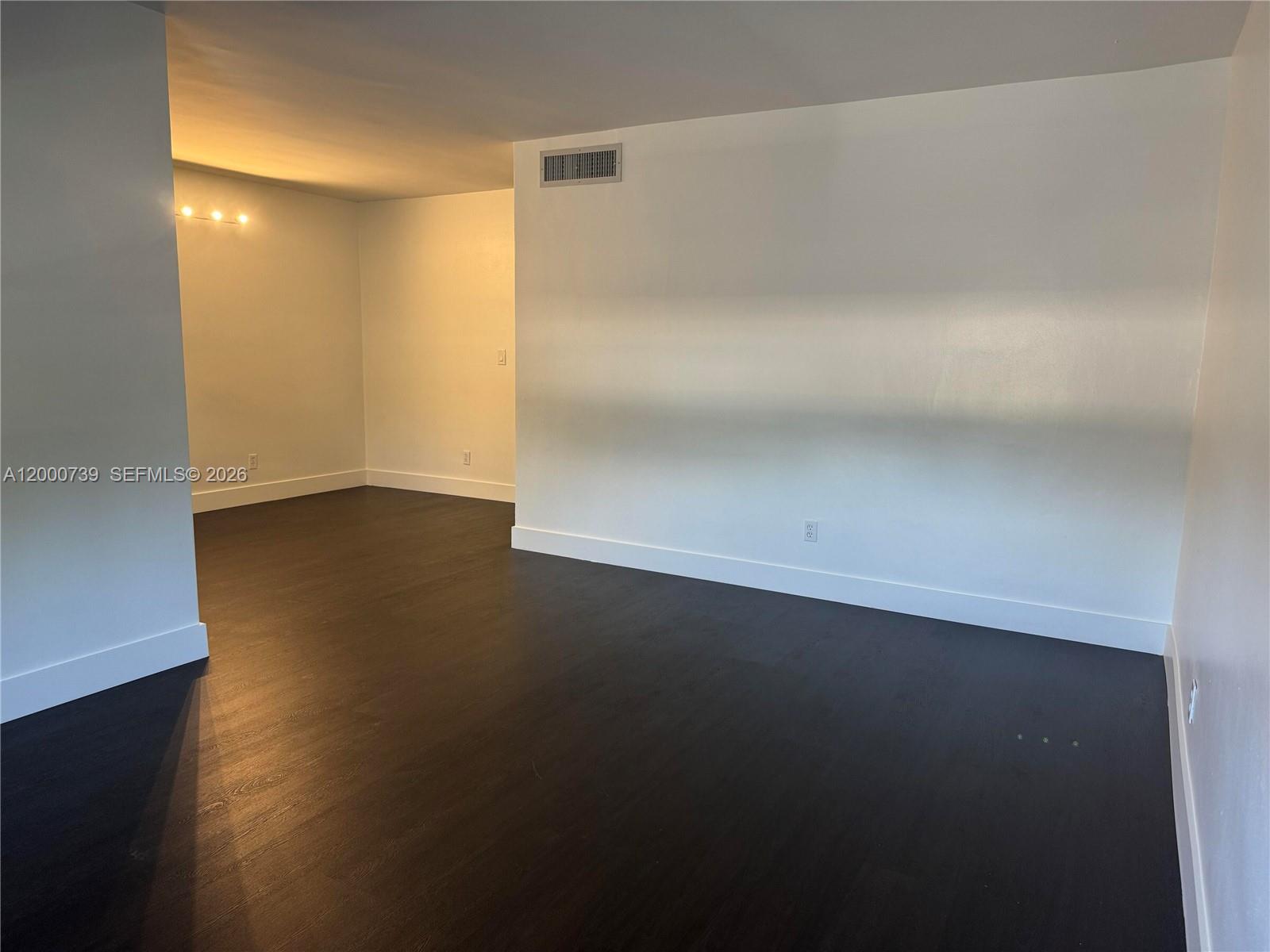An empty room features dark wood flooring, white walls, and a recessed ceiling vent — 4850 SW 26th Ave # 6, Dania Beach FL 33312, DANIA BEACH, FL
