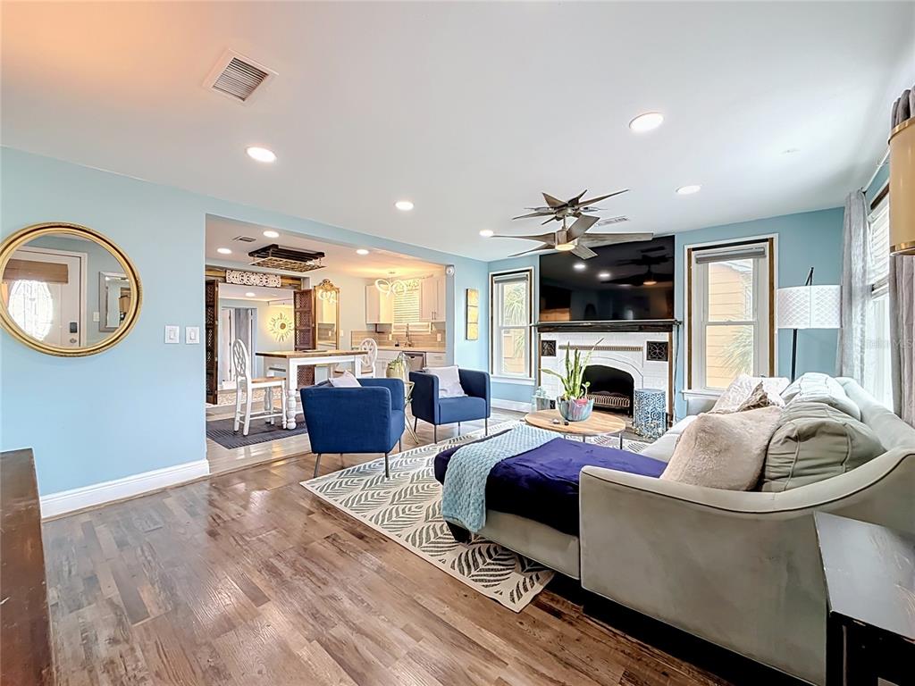 A living room with light blue walls, a fireplace, and an adjacent dining area — 4831 FAIRFIELD AVENUE S, ST PETERSBURG, FL
