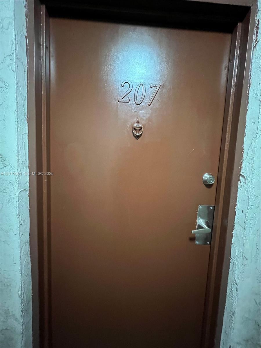 A brown apartment door labeled 207 features a peephole and a metal handle — 9431 SW 4th St # 207, Miami FL 33174, MIAMI, FL