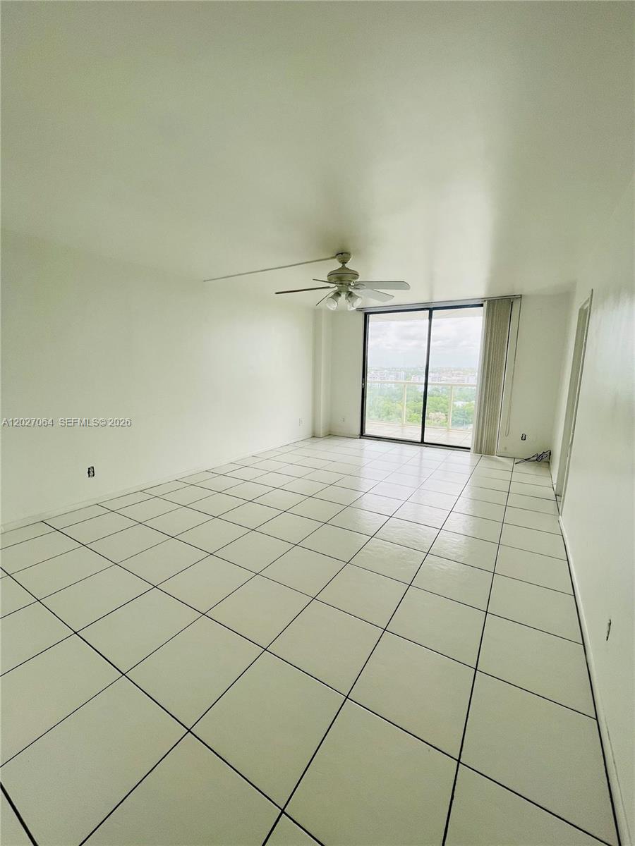 An empty room features white walls, a ceiling fan, and light-colored tiled flooring — 13499 Biscayne Blvd # 1613, North Miami FL 33181, NORTH MIAMI, FL
