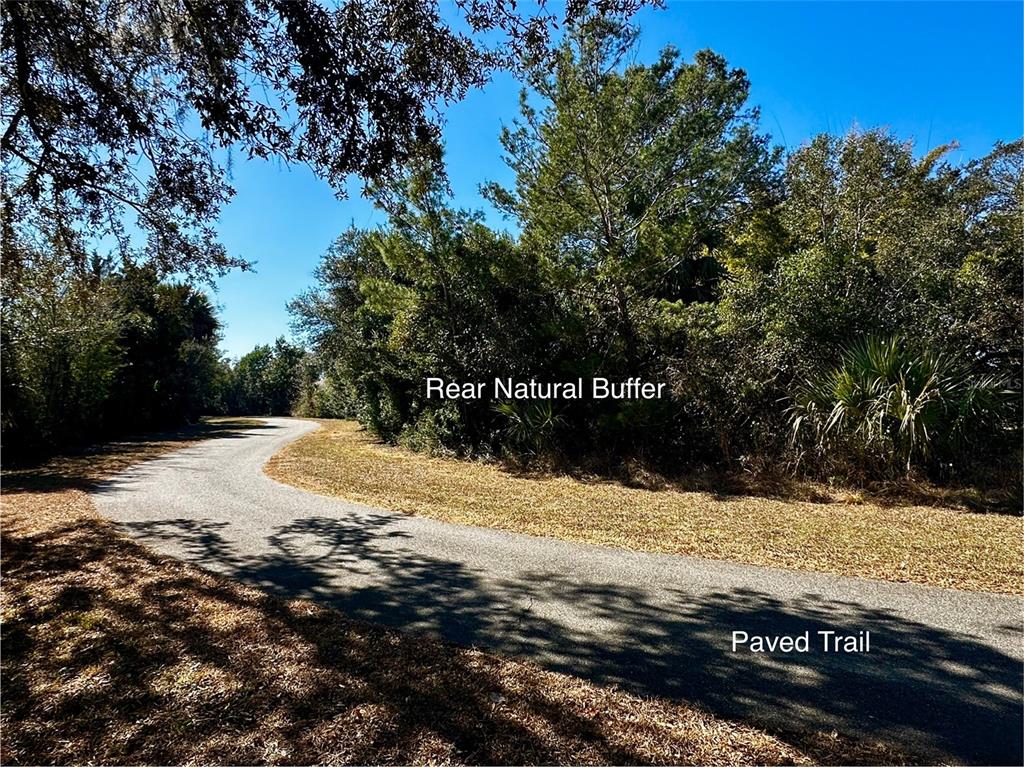 A paved trail curves through a wooded area with a natural buffer of trees — 29 FIELDSTONE LANE, PALM COAST, FL