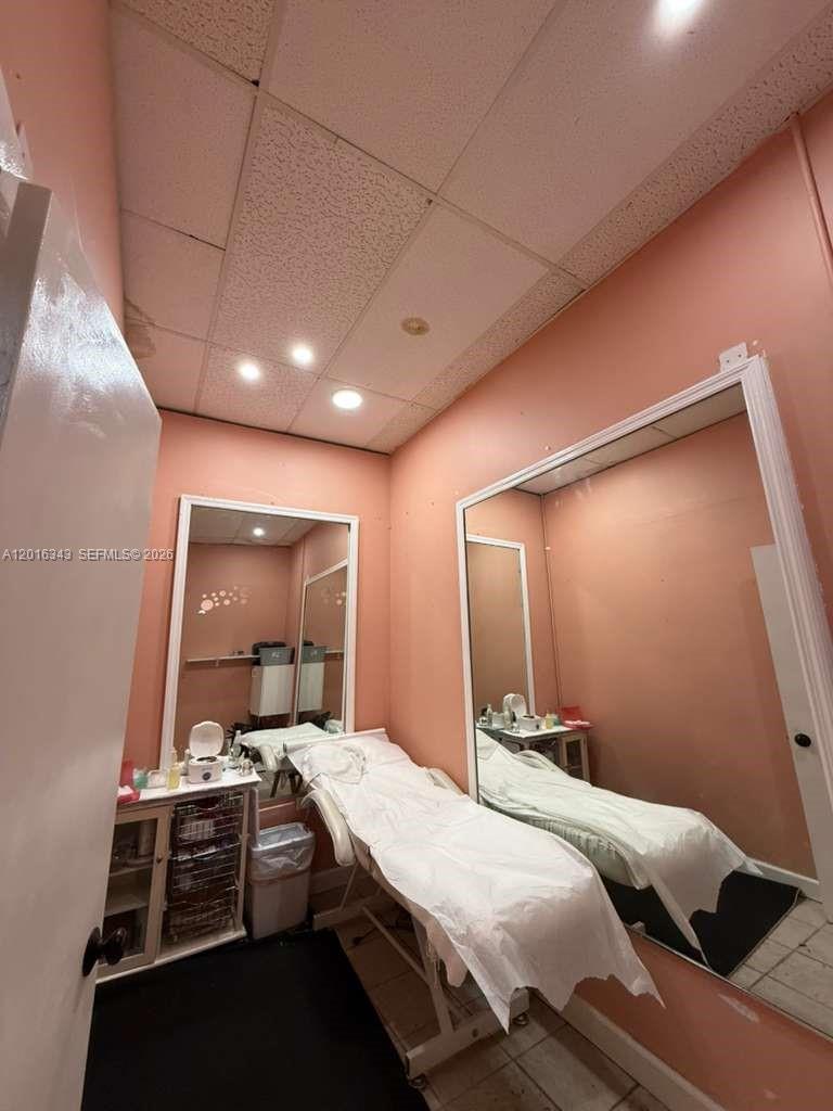 A small treatment room features a massage table, large wall mirrors, and pink walls — 6647 Taft St, Hollywood FL 33024, HOLLYWOOD, FL