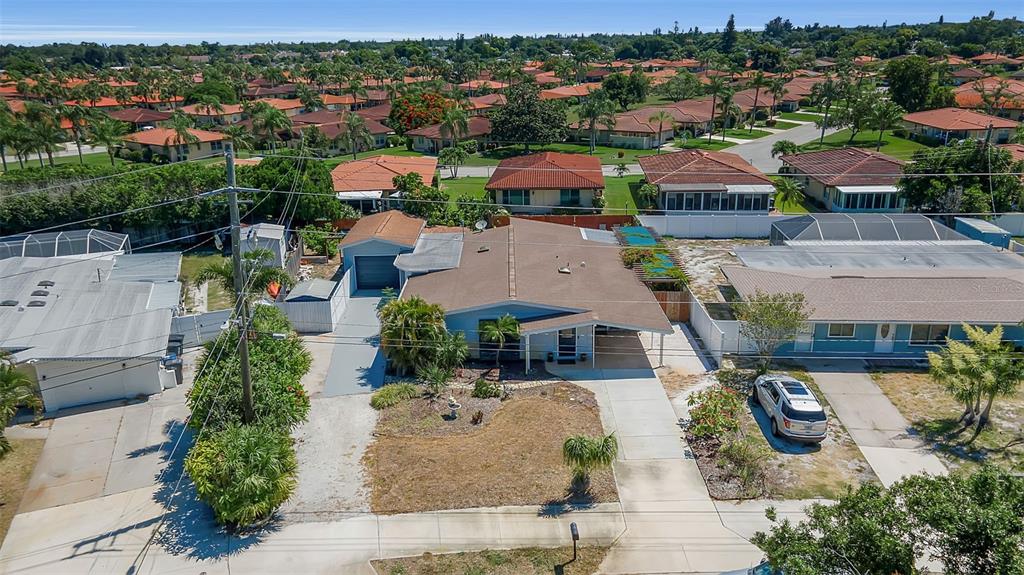 An aerial view of a single-story house with a driveway, carport, and surrounding residential neighborhood — 3303 FLORIDA BOULEVARD, BRADENTON, FL