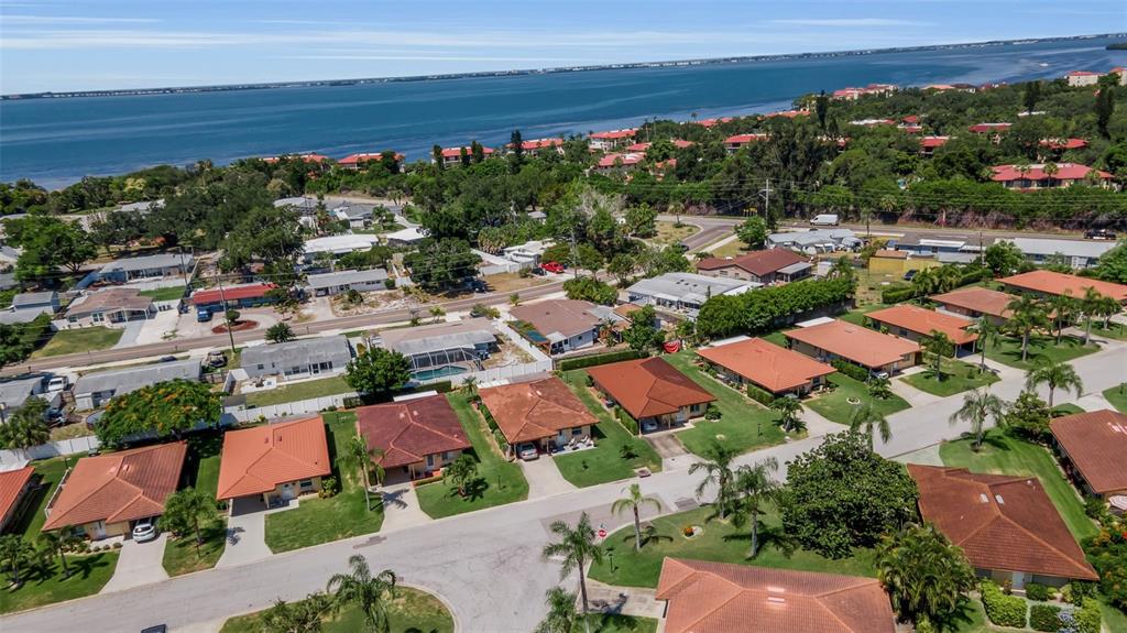 An aerial view of a suburban neighborhood featuring houses with orange roofs near the water — 3303 FLORIDA BOULEVARD, BRADENTON, FL