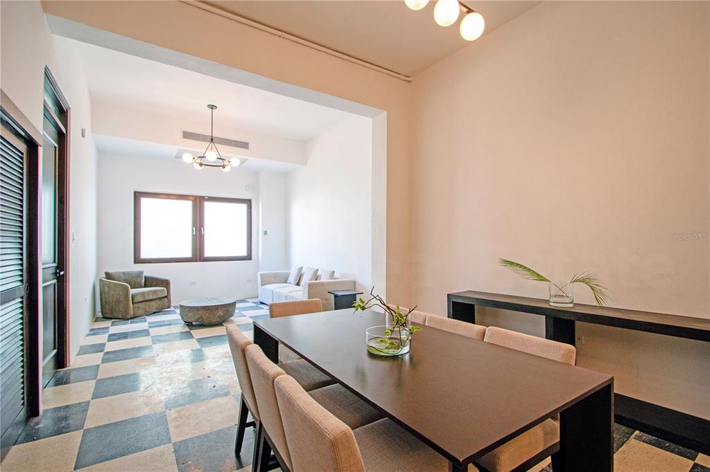 A dining area with a dark table and chairs leads into a living room with checkered floors — 254-256 SAN FRANCISCO STREET UNIT 204, SAN JUAN, PR