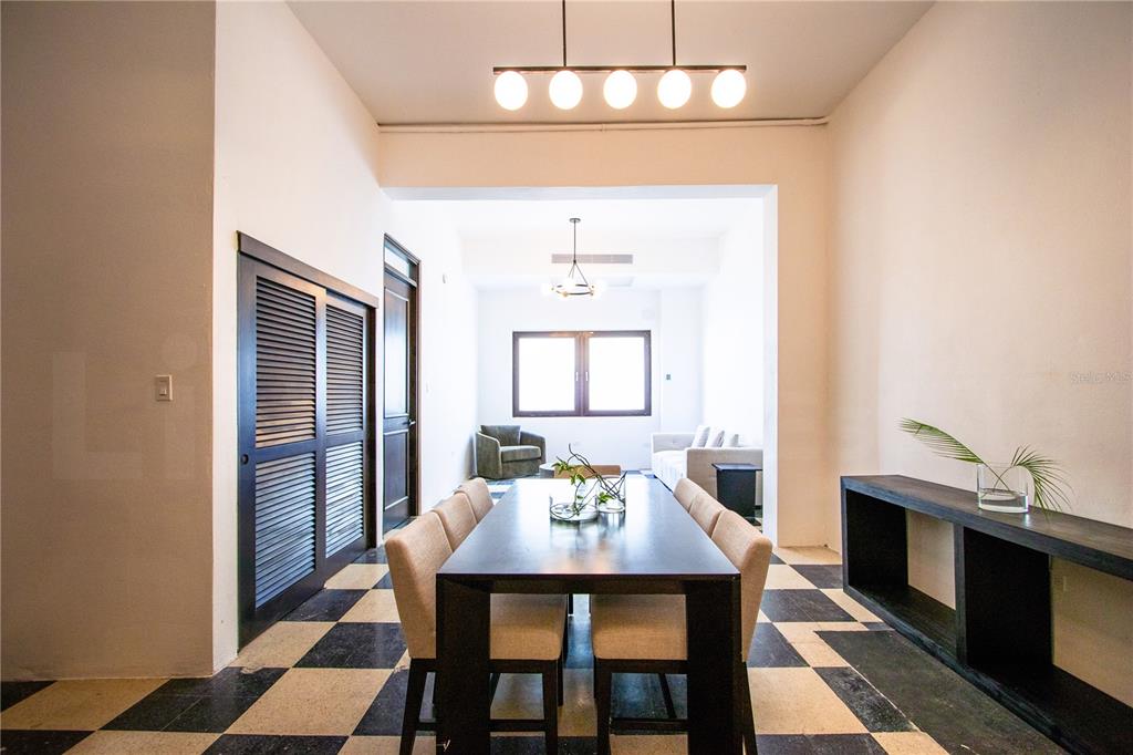 A dining room with a long dark table, light chairs, and a black-and-white checkered floor — 254-256 SAN FRANCISCO STREET UNIT 204, SAN JUAN, PR