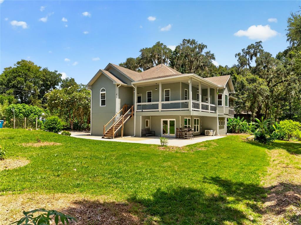 The exterior of a two-story house with a wrap-around porch and a concrete patio — 28211 MAGNON DRIVE, BROOKSVILLE, FL