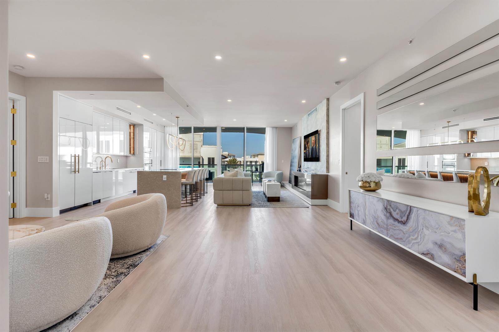 A modern open-concept living room and kitchen featuring light wood floors and floor-to-ceiling windows — 500 SE Mizner Boulevard # A902, Boca Raton FL 33432, BOCA RATON, FL